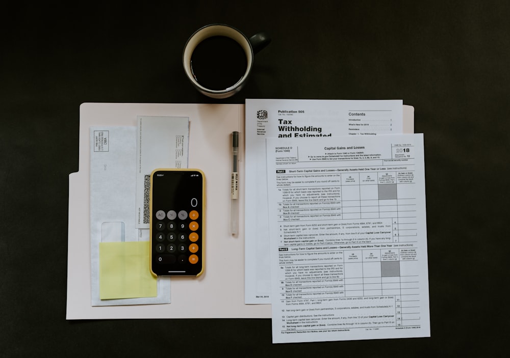 Calculator, statements and a laptop used to review processing costs